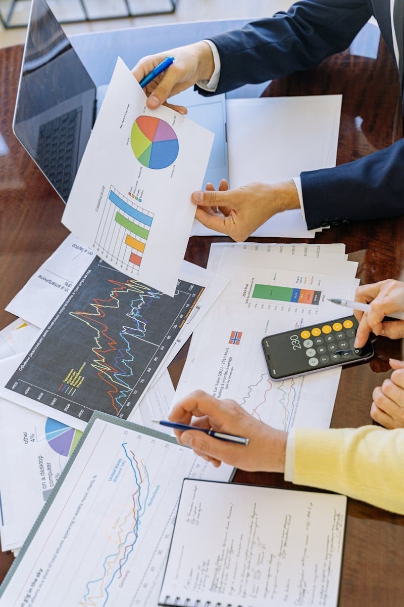 Business professionals analyzing financial charts and graphs during a meeting about lending advisory services.